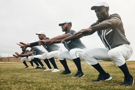 Team, stretching and baseball players for game, exercise and baseball in sportswear on field. Workout, squat and group for match prepare, wellness and fitness being being focus on baseball fieldの写真素材