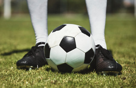 Soccer ball, football player and game of athlete on a sports field for a match wearing shoes....