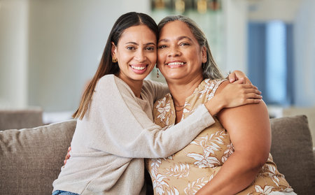 Woman, happy and hug of a mother and adult child on a home living room lounge couch with love. Portrait of people from Mexico smile on a house sofa with care, happiness and quality time togetherの写真素材