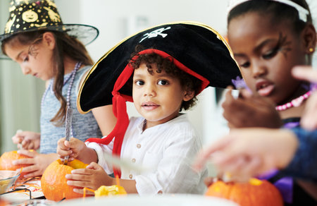 Pumpkin power. a group of little children cleaning pumpkins at a party.の写真素材