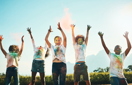 Being a kid is all about having fun. a group of teenagers having fun with colourful powder at summer camp.の写真素材