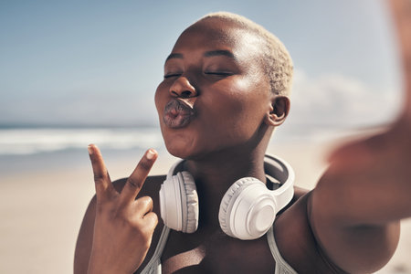Looking for peace Youll find it after your workout. a sporty young woman posing with headphones around her neck.の写真素材