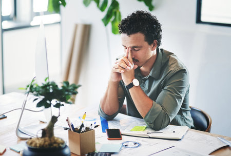 Just a bit stressed today. a young businessman in pain in an office.の写真素材