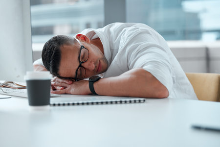 What a long day its been. a young male businessman working a call center taking a nap.の写真素材