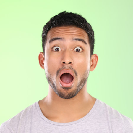No way. Cropped portrait of a handsome young man making a face against a green background in studio.の写真素材