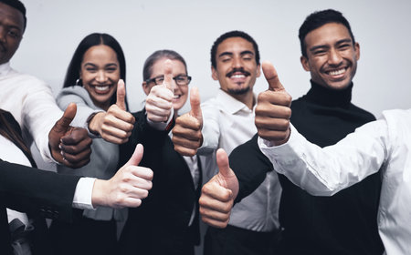 Giving this day a thumbs up. a group of businesspeople together with their thumbs up.
