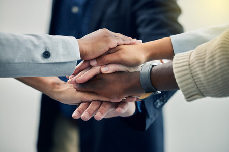 Lets put our everything into this. business colleagues with their hands stacked at work.