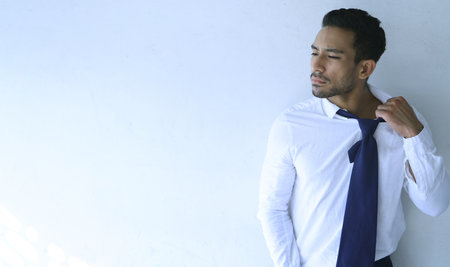 Feeling a little hot under the collar. a handsome young businessman looking depressed after being retrenched from work.の写真素材