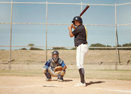 Baseball, pitcher and man with a bat on pitch playing a match or sport training as a team. Fitness, sports and men athletes practicing pitching and batting before a softball game on an outdoor field.の写真素材