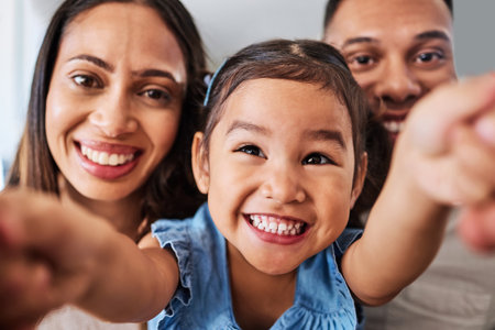 Family, selfie and happy, parents and child together, bonding and spending quality time in family home. Mother, father and kid smile, trust and love with care in closeup portrait, picture perfect.の写真素材