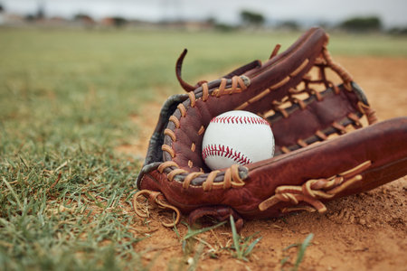 Baseball, ball and glove on an outdoor pitch for sport training, fitness or a tournament game. Exercise, sports equipment and softball match on a professional field or stadium with grass and sand.の写真素材