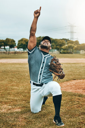 Baseball, baseball player and celebration, winner and success in match, game or competition. Happy, smile and sports male from India pointing up, celebrating victory or winning, training or workoutの写真素材