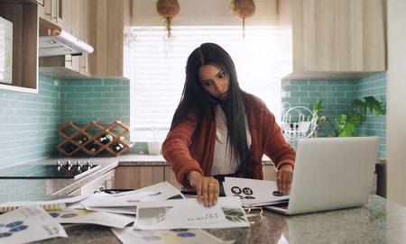 Hold on I need to find that document. a young businesswoman taking a phone call while working at...