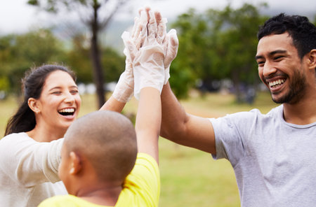 Talent wins games, teamwork wins championships. three people wearing plastic disposable gloves high fiving outdoors.の写真素材