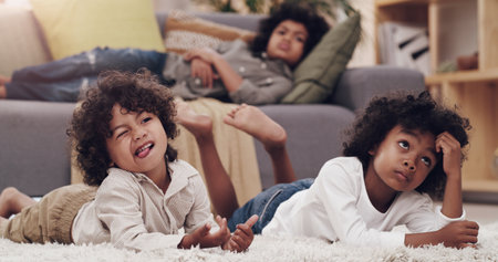Who chose this movie. three adorable little boys laying and watching tv together at home.の写真素材