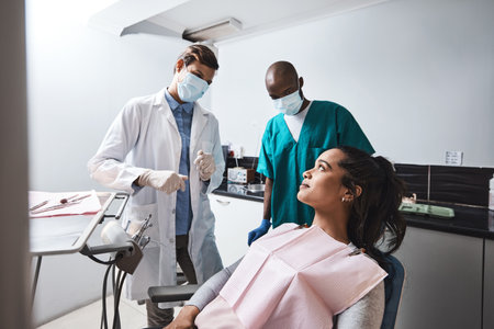 A quick chat puts the patients mind at ease. a young woman having a consultation with her dentist.の写真素材