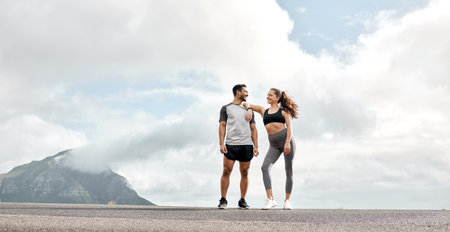 A good run can transport you to another place. a sporty young man and woman exercising together outdoors.の写真素材