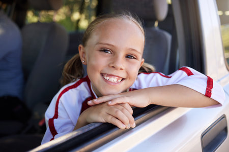 Happy, little girl and portrait smile for road trip in relax after soccer match in the car. Excited female teenager smiling in happiness for sports vacation, travel or training for football gameの写真素材