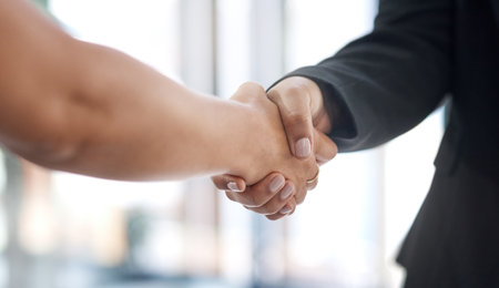 Networking is about sharing, not taking. Closeup shot of two unrecognisable businesswomen shaking hands in an office.の写真素材