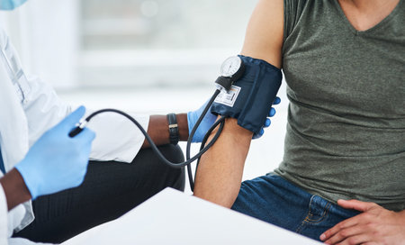 The one test you dont want to score high in. a doctor examining a man with a blood pressure gauge.