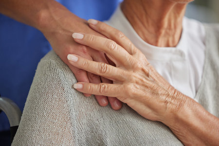 Comfort, hand and nurse with senior for care in wheelchair at house, nursing home or retirement....