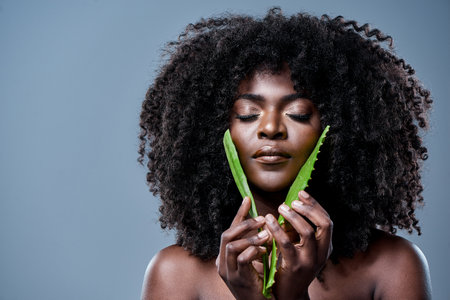 Nature heals the mind, body and soul. a beautiful young woman posing with an aloe vera plant against her skin.の写真素材
