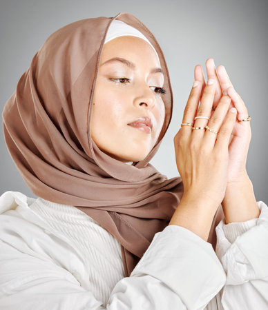 Hijab, jewelry and fashion of woman in islam beauty headshot with makeup or cosmetics in a studio mock up. Arab, muslim or arabic model wearing scarf fabric and ring on hands with mockup backgroundの写真素材
