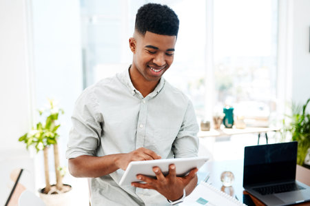 Taking the smarter route to success. a young businessman using a digital tablet in a modern office.