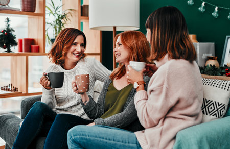 I always have time for the two of you. three attractive middle aged women having coffee together during Christmas eve at home.の写真素材