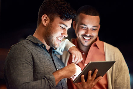 You have access to anything. two businessmen looking at a digital tablet while standing outside at...