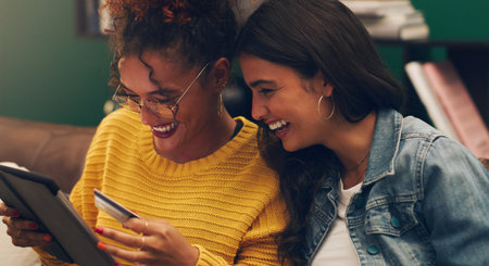 Check out the two for one special. two friends browsing online while using a credit card.