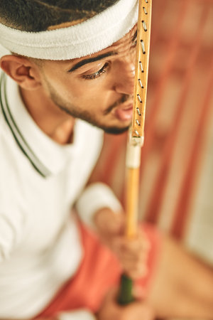 Okay racket, lets do this. a young man pressing his face up against his squash racket.