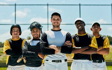 We make hit runs when were together. Cropped portrait of a group of baseball players standing with their arms folded on the field during the day.の写真素材