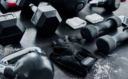 What to choose. High angle shot of fitness workout essentials placed on top of a dark background inside of a studio.の写真素材