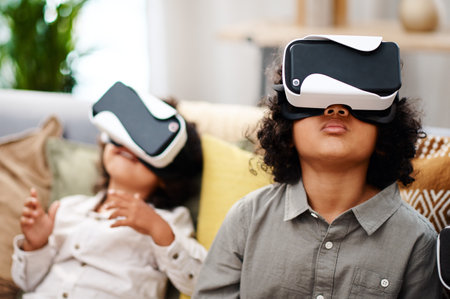 Nothings inspires curiosity like technology. two little boys watching movies together through virtual reality headsets at home.の写真素材