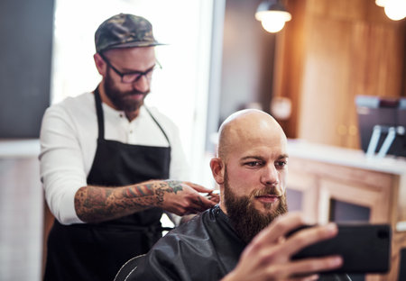 You can call me Mr. Clean now. a handsome young man getting a haircut at a barbershop.の写真素材
