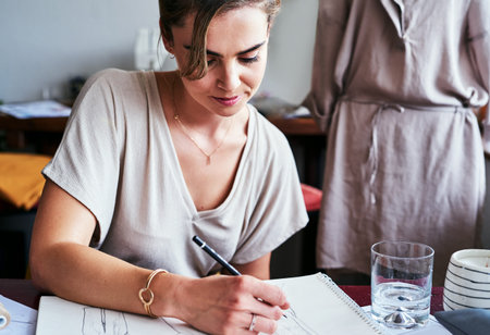 Theres nothing that I love more than my job. a fashion designer working on new sketches at her desk.
