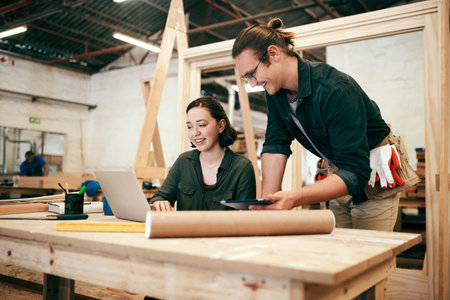 Were handling the digital side of business today. two young carpenters using a laptop and digital...