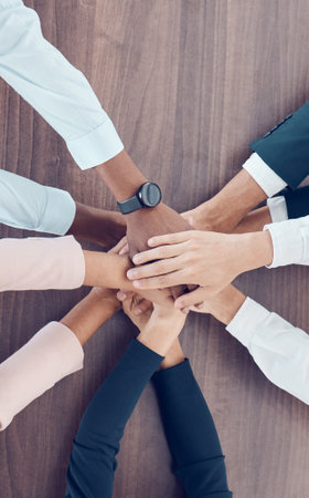 Teamwork hands, collaboration and motivation of business people, trust and growth mission with vision, partnership and support. Above group celebration on table, company goals and corporate diversityの写真素材