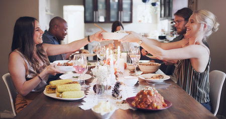 Lets get to feasting. a group of young friends having a festive meal together at home.