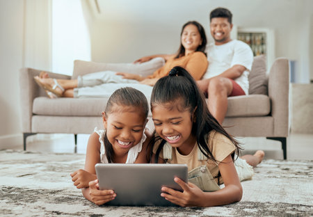 Children, tablet or relax parents in living room of house or family home for education video, movie streaming or internet esports. Smile, happy or bonding kids on technology and watching man or womanの写真素材