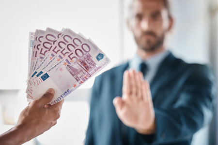 Bribe, money and fraud businessman stop hands for money laundering, corruption and business deal exchange. Crime, ethics and lawyer business people euro cash offer for financial scam or secret profitの写真素材