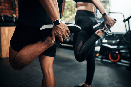Your body will thank you in the long run. two sporty young people working out together at the gym.の写真素材