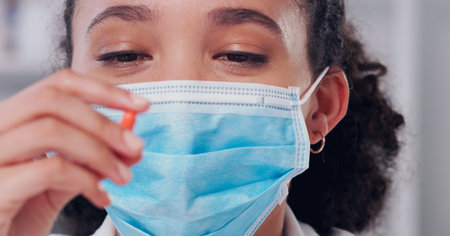 I hope this cure works. a young scientist holding a pill in her hand while working in a lab.