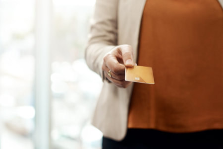 Spending wisely is key in remaining successful. an unrecognizable businesswoman holding a credit...