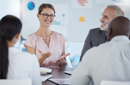 Business people, team and meeting discussion for idea, conversation or company solution in analysis at the office. Happy woman employee analyst sharing ideas in collaboration, teamwork or workshopの写真素材