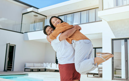 Hug, real estate and couple moving into their new home while excited, happy and with smile together. Portrait of a young, hugging and man and woman with love and happiness at their dream houseの写真素材