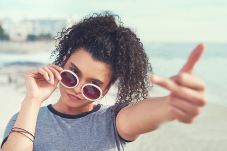 Dont you dare throw shade. a young woman showing middle finger.の写真素材