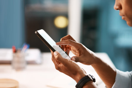 Hes adding a nice touch to his business dealings. an unrecognizable businessman using a digital tablet while working late in his office.の写真素材