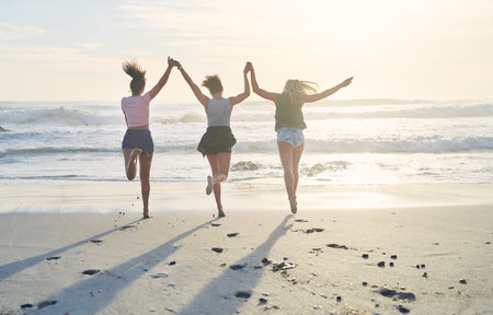No one loves the beach as much as we do. three friends spending the day at the beach.の写真素材